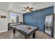 A well-appointed game room with a beautiful pool table, custom accent wall, and abundant light at 3445 E Pageant Pl, Gilbert, AZ 85297