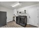 A clean laundry room with modern washer and dryer units, storage, sink, and tiled floors at 3445 E Pageant Pl, Gilbert, AZ 85297