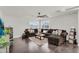 Comfortable living room with a spacious sectional, wood floors, and bright windows at 3445 E Pageant Pl, Gilbert, AZ 85297