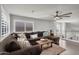 Spacious living room with brown sectional, ceiling fan, wood floors and upstairs view at 3445 E Pageant Pl, Gilbert, AZ 85297