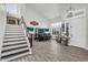 Open-concept living room with stairs, built-in bar, and plank-style tile flooring at 3445 E Pageant Pl, Gilbert, AZ 85297