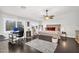 Spacious main bedroom with dark wood floors, upholstered bed, and a dedicated workspace at 3445 E Pageant Pl, Gilbert, AZ 85297