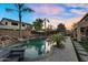 Luxurious backyard with a stunning pool, a rock waterfall feature, and lush landscaping, creating a private oasis at 3445 E Pageant Pl, Gilbert, AZ 85297