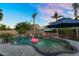 Resort-style backyard with a beautiful pool, palm trees, and shaded seating areas, ideal for relaxation and entertainment at 3445 E Pageant Pl, Gilbert, AZ 85297