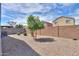 Private backyard with a tree, rock landscape, mature bushes, and a block fence that offers privacy at 36522 W Santa Monica Ave, Maricopa, AZ 85138