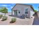 View of the backyard of the home with a neutral colored exterior, bushes, and gravel at 36522 W Santa Monica Ave, Maricopa, AZ 85138