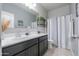Bathroom featuring a white vanity countertop, dark cabinets, gray walls, and a shower and tub at 36522 W Santa Monica Ave, Maricopa, AZ 85138