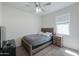 Bedroom boasts natural lighting, a ceiling fan, wooden bed frame, and a modern nightstand at 36522 W Santa Monica Ave, Maricopa, AZ 85138