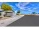 Exterior view of the home's facade with a gray garage door, landscaping, and sidewalk at 36522 W Santa Monica Ave, Maricopa, AZ 85138