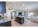 Bright, open kitchen showcasing a granite island with sink and stainless-steel appliances at 36522 W Santa Monica Ave, Maricopa, AZ 85138