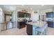 Modern kitchen with stainless steel appliances, an island with barstool seating, and dark cabinetry at 36522 W Santa Monica Ave, Maricopa, AZ 85138