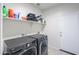 Laundry room with new gray washer and dryer set, overhead storage shelf and bright doorway at 36522 W Santa Monica Ave, Maricopa, AZ 85138