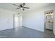 This bedroom includes gray tile flooring, neutral walls, ceiling fan, a closet, and an ensuite bath at 3722 W Michelle Dr, Glendale, AZ 85308