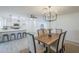Open-concept dining area with a modern chandelier and adjacent kitchen island for seamless entertaining at 3722 W Michelle Dr, Glendale, AZ 85308