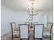 Dining room with a modern chandelier, wood table with seating for six, and a view to the modern kitchen at 3722 W Michelle Dr, Glendale, AZ 85308