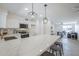 Open kitchen with breakfast bar, stainless appliances, modern lighting, and white cabinets flowing into the living area at 3722 W Michelle Dr, Glendale, AZ 85308
