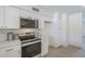This kitchen has stainless steel appliances, white cabinets with gold hardware, marble backsplash, and updated lighting at 3722 W Michelle Dr, Glendale, AZ 85308