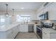 Bright kitchen features white cabinets, stainless steel appliances, marble countertops, and a view to the backyard at 3722 W Michelle Dr, Glendale, AZ 85308