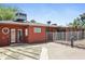 View of the backyard of the home with red exterior, fenced area, and patio at 3836 W Desert Cove Ave, Phoenix, AZ 85029