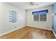 Bright bedroom with hardwood floors, a ceiling fan and a decorative painted brick wall at 3836 W Desert Cove Ave, Phoenix, AZ 85029