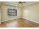 Simple bedroom with wood floors, a ceiling fan and a sunlit window at 3836 W Desert Cove Ave, Phoenix, AZ 85029