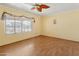 Bright bedroom with wood laminate flooring, yellow walls, and a leafy ceiling fan at 3836 W Desert Cove Ave, Phoenix, AZ 85029