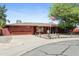 Charming single-story home with an American flag, desert landscaping, and a red brick exterior at 3836 W Desert Cove Ave, Phoenix, AZ 85029