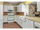 Well-lit kitchen showcasing white cabinets, updated appliances, and a vintage-style sink at 3836 W Desert Cove Ave, Phoenix, AZ 85029