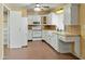 Functional kitchen featuring white appliances, tile countertops, and ample cabinet space at 3836 W Desert Cove Ave, Phoenix, AZ 85029