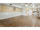 Spacious living room with stone tile flooring, white wainscoting, and adjacent kitchen at 3836 W Desert Cove Ave, Phoenix, AZ 85029