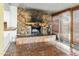 Cozy living room featuring a stone fireplace and tile flooring for a rustic, inviting atmosphere at 3836 W Desert Cove Ave, Phoenix, AZ 85029