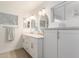 Bathroom with double sinks, modern fixtures, and plenty of storage in white cabinetry at 3971 N 151St Ln, Goodyear, AZ 85395