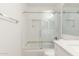 Modern bathroom features a shower-over-tub with white tiling, glass doors and vanity with storage at 3971 N 151St Ln, Goodyear, AZ 85395