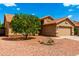 Single-story home featuring desert landscaping with a lush tree, providing shade and curb appeal at 3971 N 151St Ln, Goodyear, AZ 85395
