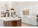 Modern kitchen with island, stainless steel appliances, and pendant lighting for a sleek and functional space at 3971 N 151St Ln, Goodyear, AZ 85395