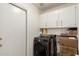 Laundry room with gray front load washer and dryer plus overhead cabinets for storing detergent and supplies at 3971 N 151St Ln, Goodyear, AZ 85395