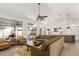 Bright living room with large sofa, ceiling fan, wood floor and view to backyard at 3971 N 151St Ln, Goodyear, AZ 85395