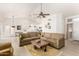 Spacious living room with large sofa, ceiling fan, wood floor and open to kitchen at 3971 N 151St Ln, Goodyear, AZ 85395