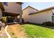 View of the backyard showing the partially covered patio and a grassy area with a retaining wall at 4068 E Devon Dr, Gilbert, AZ 85296