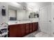 Bathroom featuring dual sinks, cherry cabinets, and large mirror at 4068 E Devon Dr, Gilbert, AZ 85296