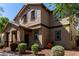 Inviting two-story home featuring a cozy front porch, desert landscaping, and a warm, neutral color palette at 4068 E Devon Dr, Gilbert, AZ 85296
