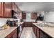 Updated kitchen featuring stone countertops, stainless appliances, and dark brown cabinets at 4068 E Devon Dr, Gilbert, AZ 85296