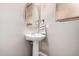 Well-lit powder room with a pedestal sink, oval mirror, and neutral paint, creating a clean and simple space at 4068 E Devon Dr, Gilbert, AZ 85296