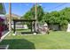 Backyard featuring a pergola with swing, fireplace, pavers, mature trees, and vibrant greenery at 4111 N 52Nd St, Phoenix, AZ 85018