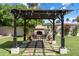 Backyard pergola with outdoor fireplace, string lights, pavers, plants and seating at 4111 N 52Nd St, Phoenix, AZ 85018