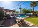 Lovely backyard featuring a dining area, pool view, string lights and mature landscaping at 4418 E Paradise Ln, Phoenix, AZ 85032