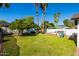Large backyard with lush lawn, mature trees, and a playground, perfect for and outdoor activities at 4418 E Paradise Ln, Phoenix, AZ 85032