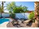 Relaxing backyard features a firepit with bench seating, palm trees, and a view of lush greenery at 4418 E Paradise Ln, Phoenix, AZ 85032