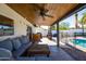 Stylish covered patio with a wood ceiling, fan, comfortable seating and access to the backyard and pool at 4418 E Paradise Ln, Phoenix, AZ 85032