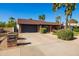 Traditional brick home with a well-maintained lawn, a two-car garage, and desert landscaping with palm trees at 4418 E Paradise Ln, Phoenix, AZ 85032